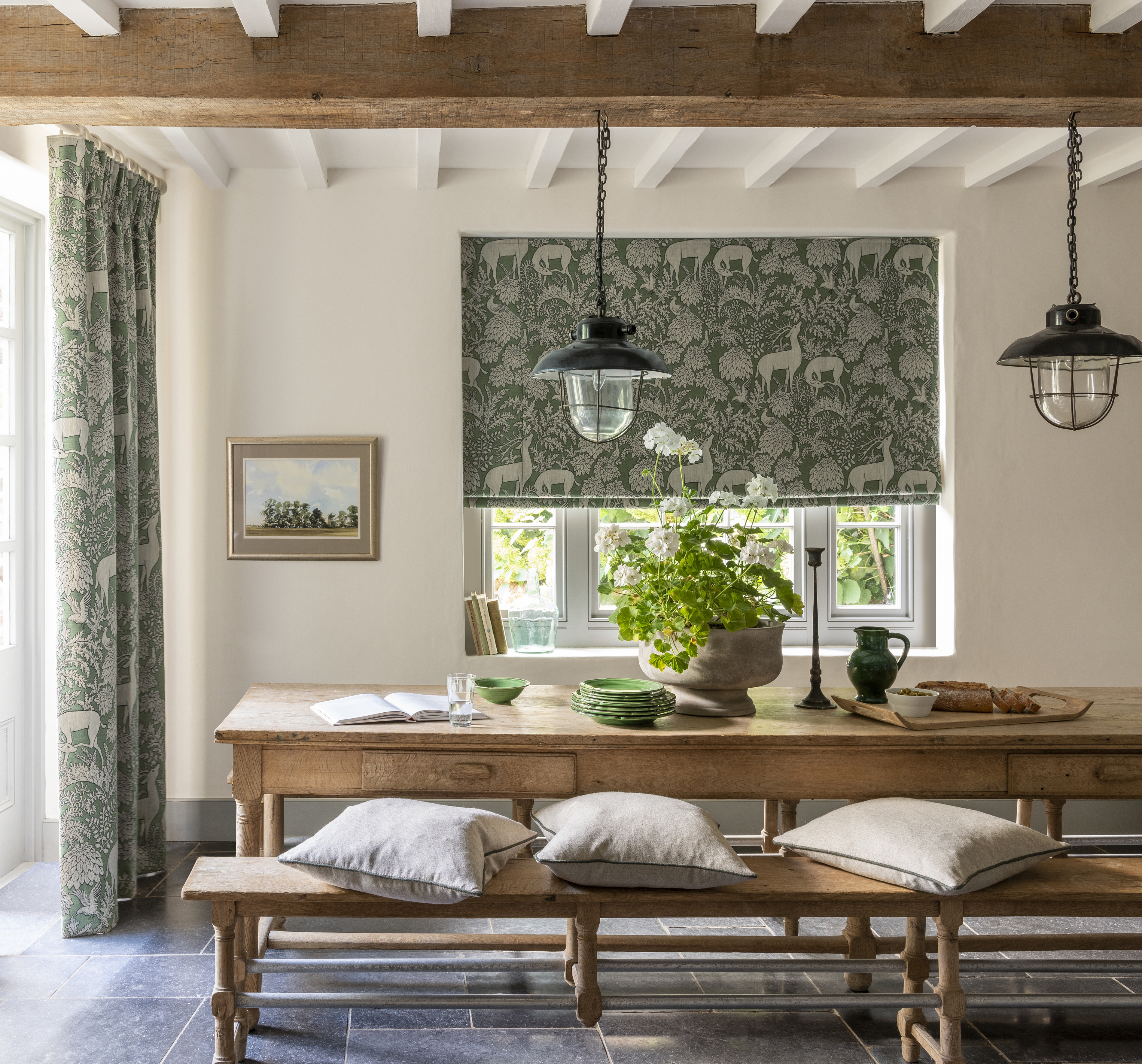 rustic dining room with matching curtains and blinds, stone flooring, cream walls