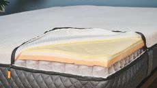 Mattress unzipped to show pocket coils and foam comfort layers on top