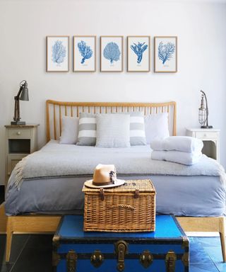 Bed with blue bedding and coastal artwork