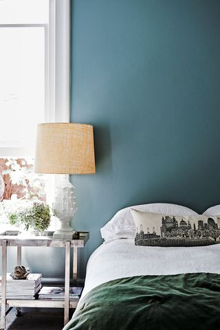 Blue bedroom with white bedroom and white bedside lamp