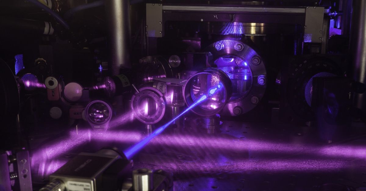 To make this quantum gas atomic clock, researchers used multiple lasers to cool strontium atoms and trap them in a grid of light. Then, a blue laser beam excites the cube-shaped cloud of the atoms. 