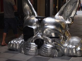 Giant silver sculpture of a sleeping dog