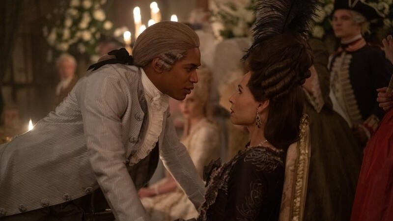 Kelvin Harrison Jr. leans over a sitting Minnie Driver in Chevalier