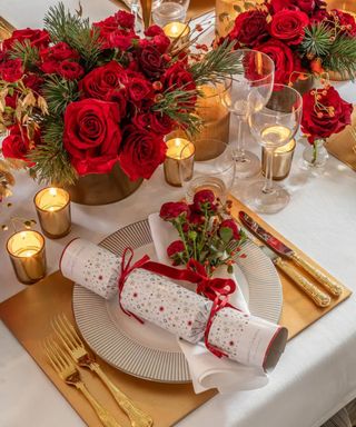 A white, gold, and red Christmas table setting