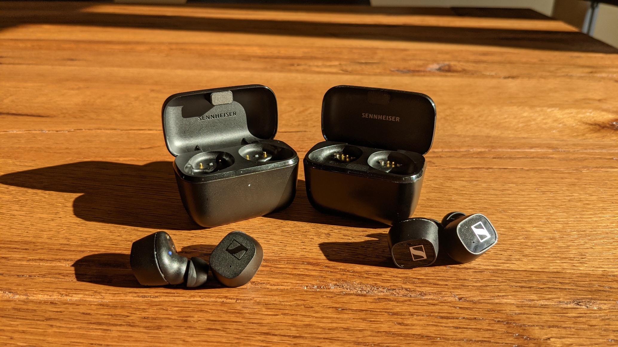 Sennheiser CX True Wireless links und Sennheiser CX 400BT mit Cases nebeneinander auf einem Tisch