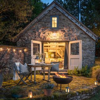 wishbone cottage barn doors open cobble patio lit and festoon lights