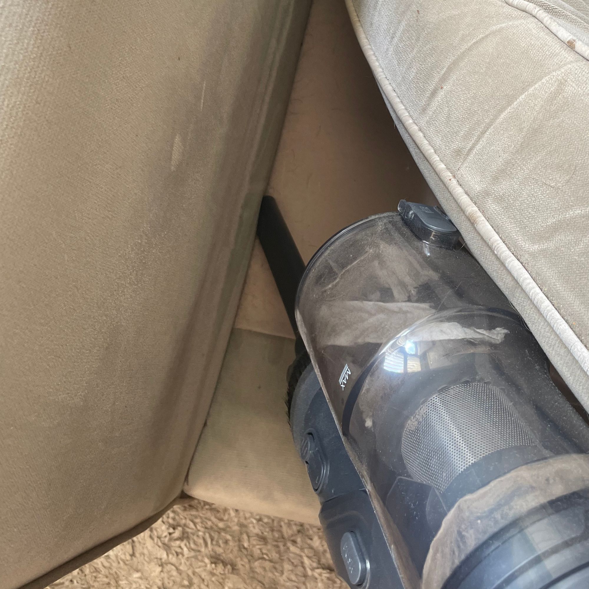 Using the crevice tool of the Ultenic U20 to clean a beige sofa