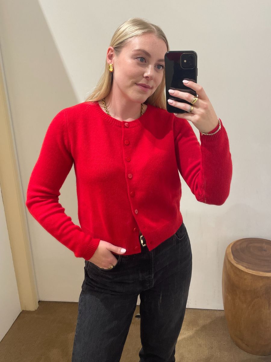 Woman wears red cardigan, black trousers