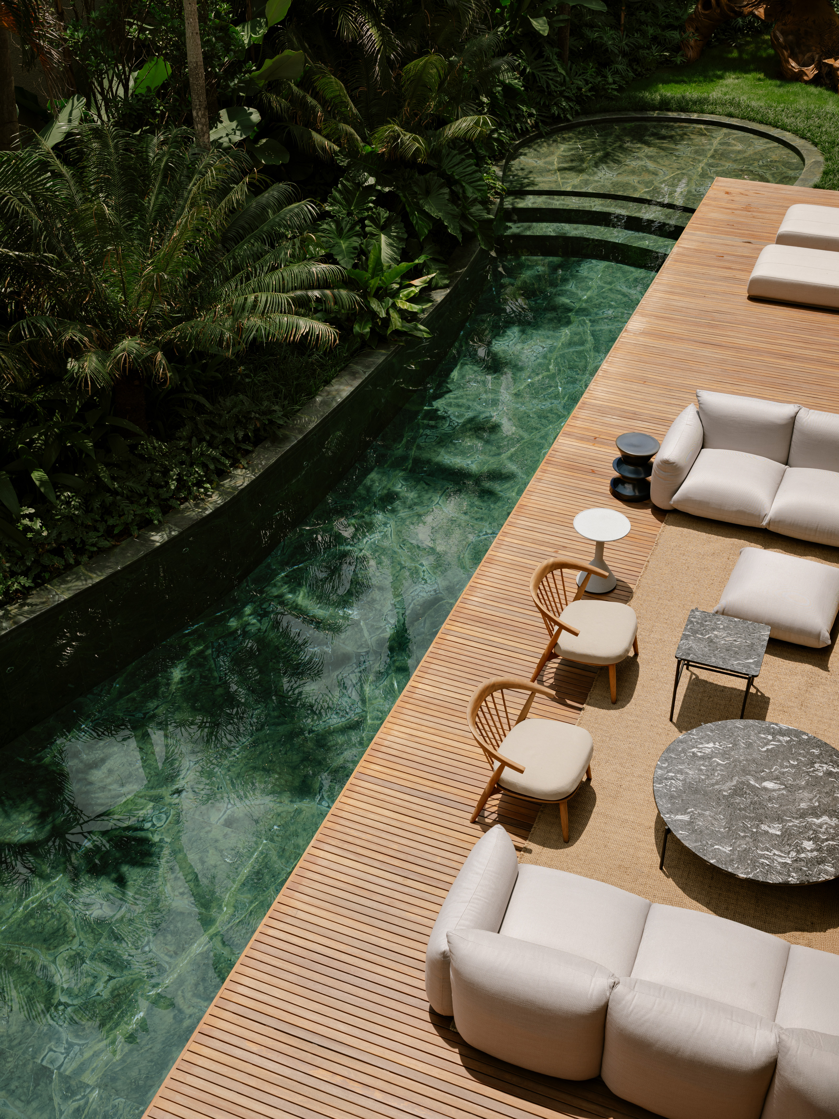 The pool is fringed with planting and clad in green tiles