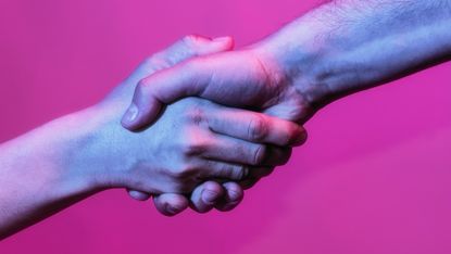 Hands of a man and a woman are connected by a handshake. Metaphor of rescue, love, assistance.