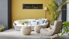 garden ideas: outdoor living area with a yellow painted wall