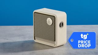 Edifier ES20 Bluetooth speaker in ivory photographed on a gray table in front of a blue background. 