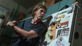Hank (Austin Butler) readies a baseball bat in his kitchen inside his apartment in a scene from "Caught Stealing"