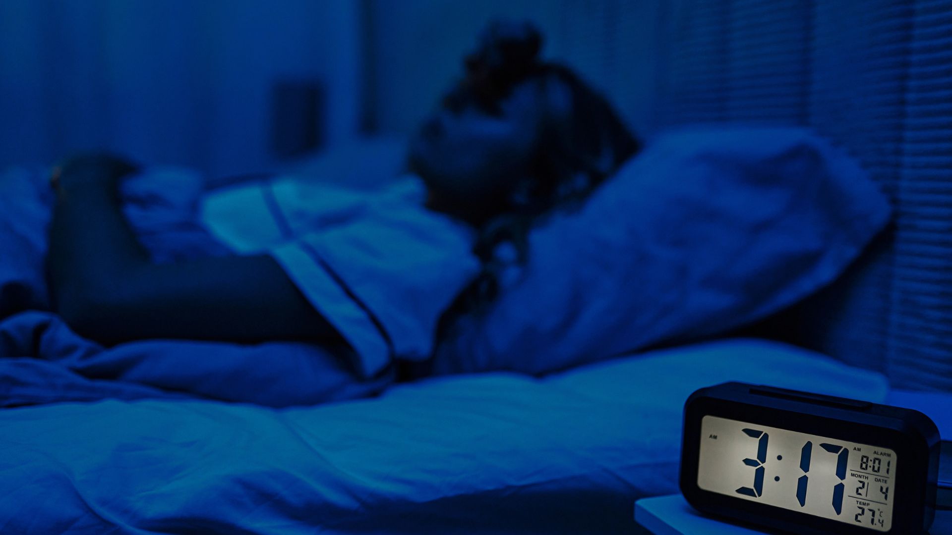 A woman lies in bed awake shortly after 3 am.