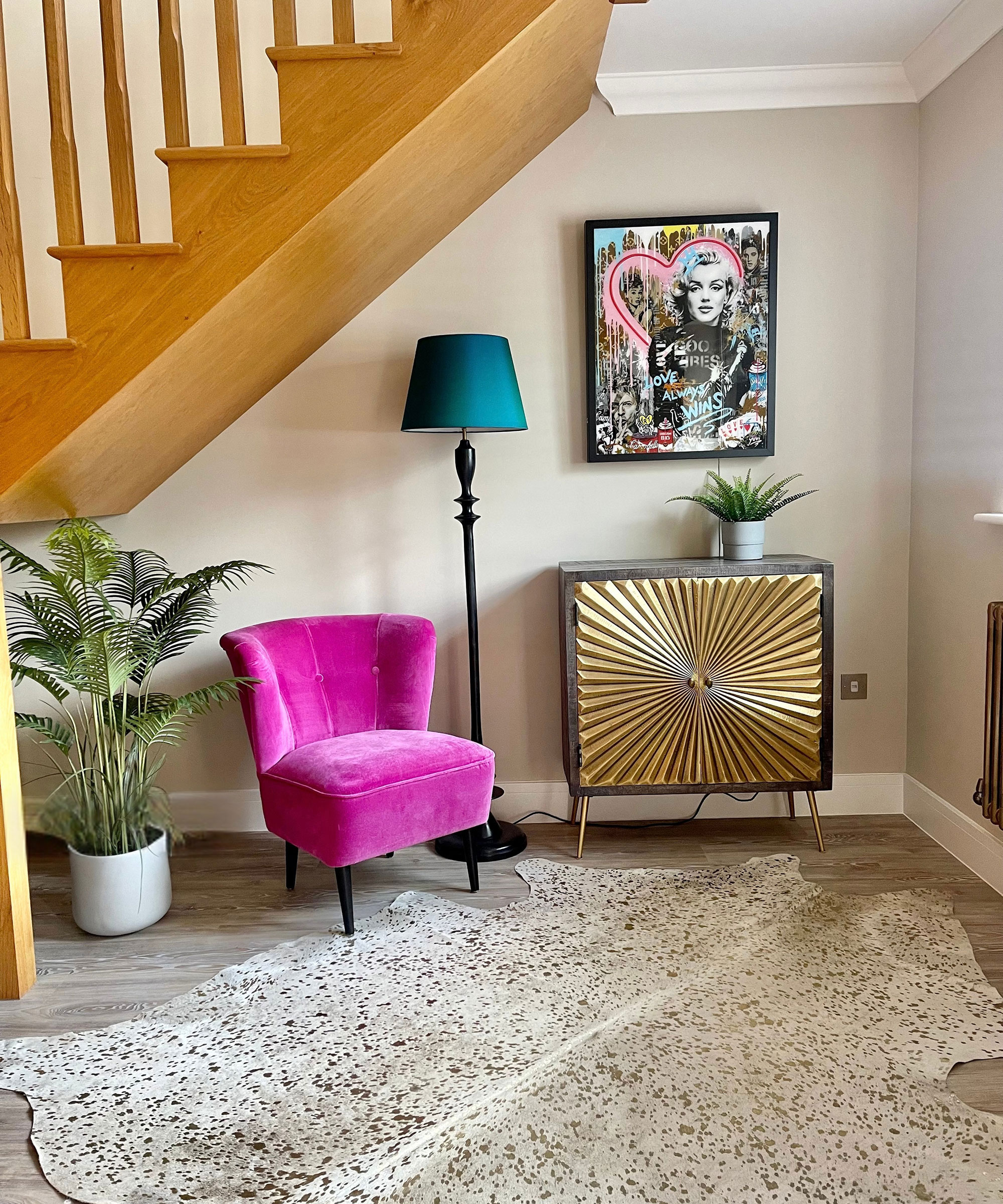 understairs space with pink armchair and cold console table