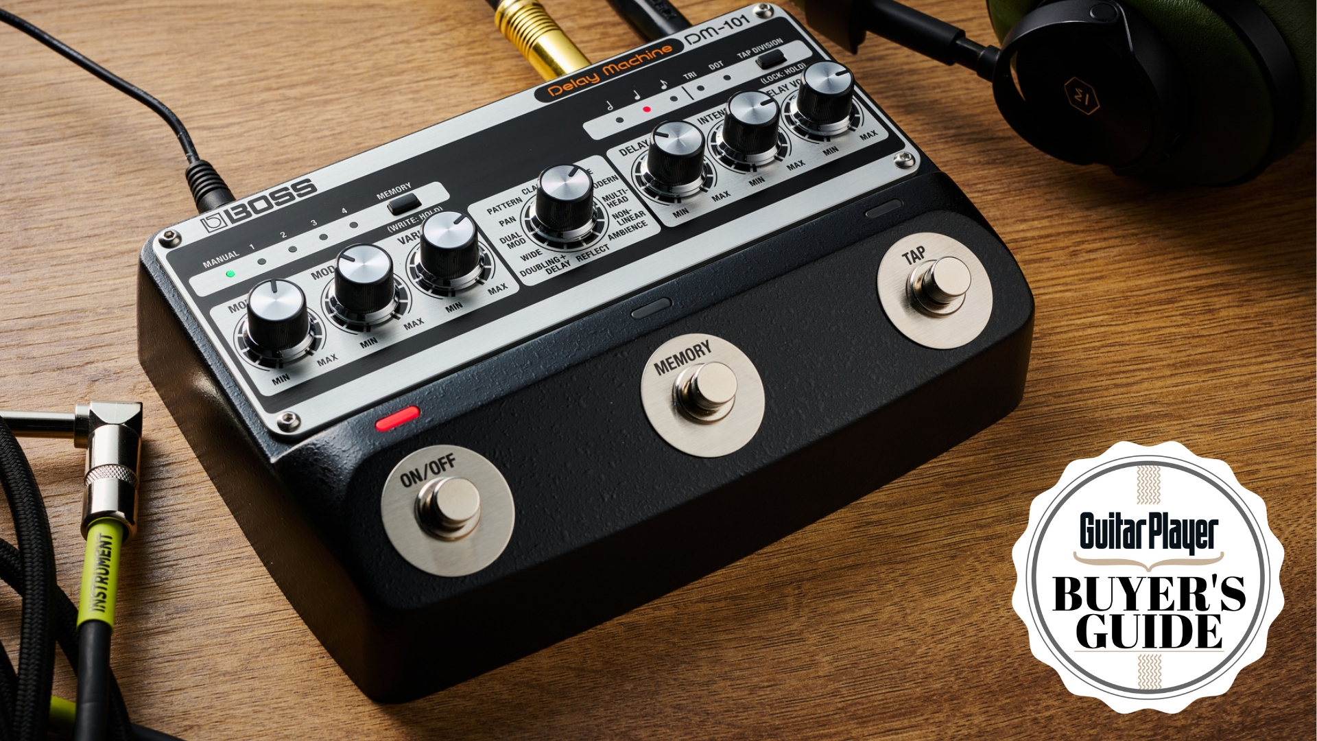 A Boss DM-101 delay pedal on a wooden desk