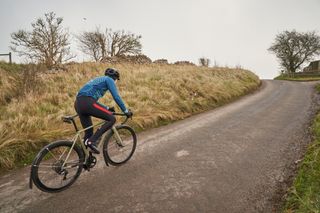 Image shows a rider cycling through the winter