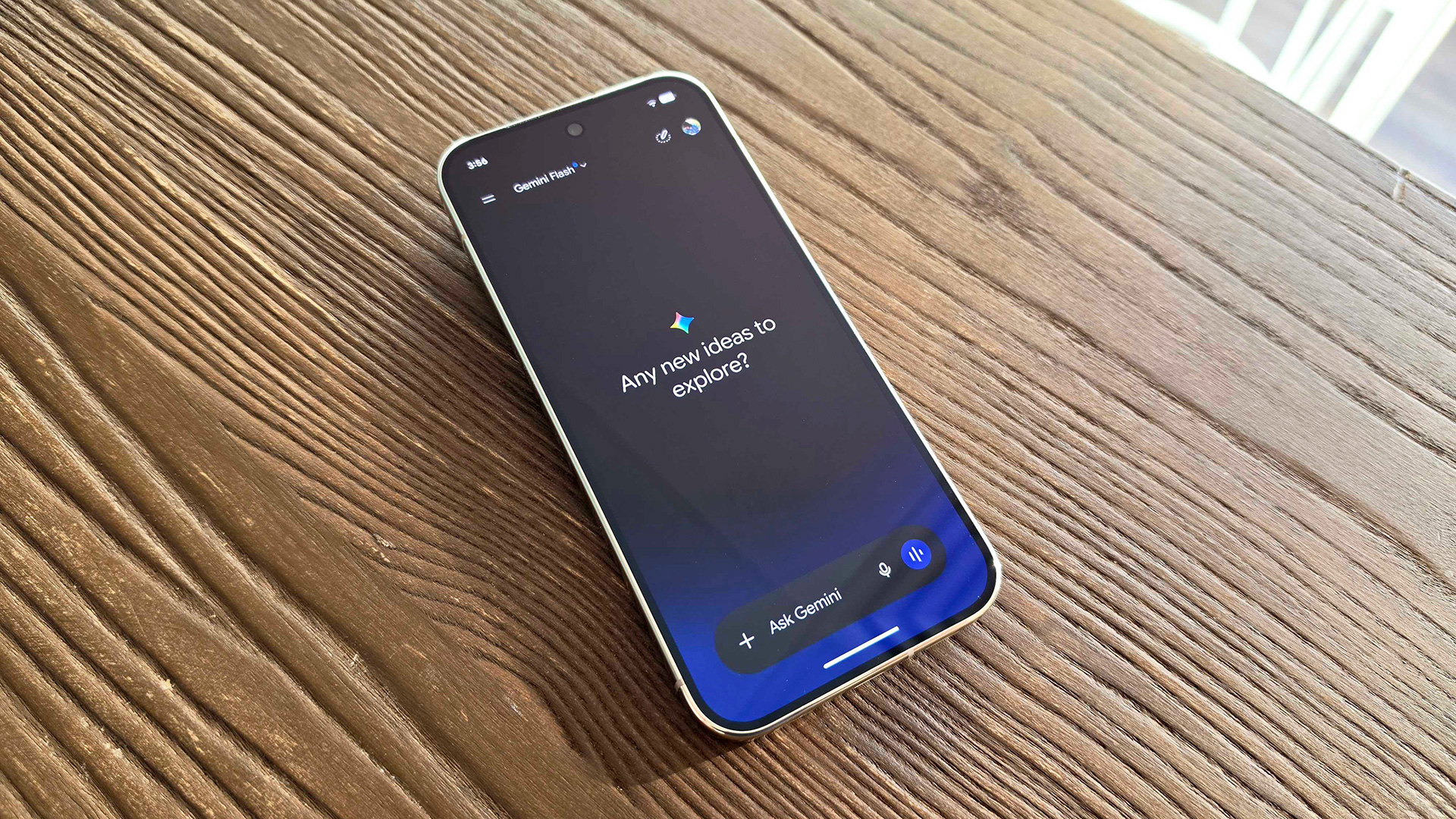 Google Pixel 11 Pro laying on table with Gemini app asking "Any new ideas to explore?"