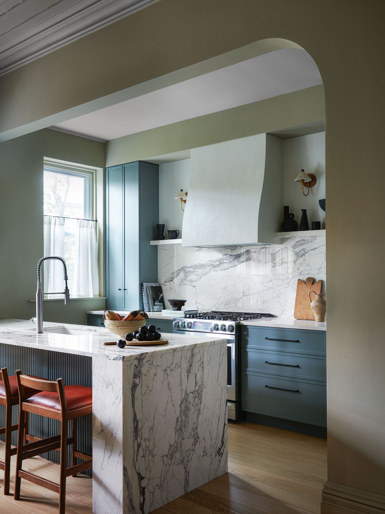 A marble-themed kitchen with blue cabinetry
