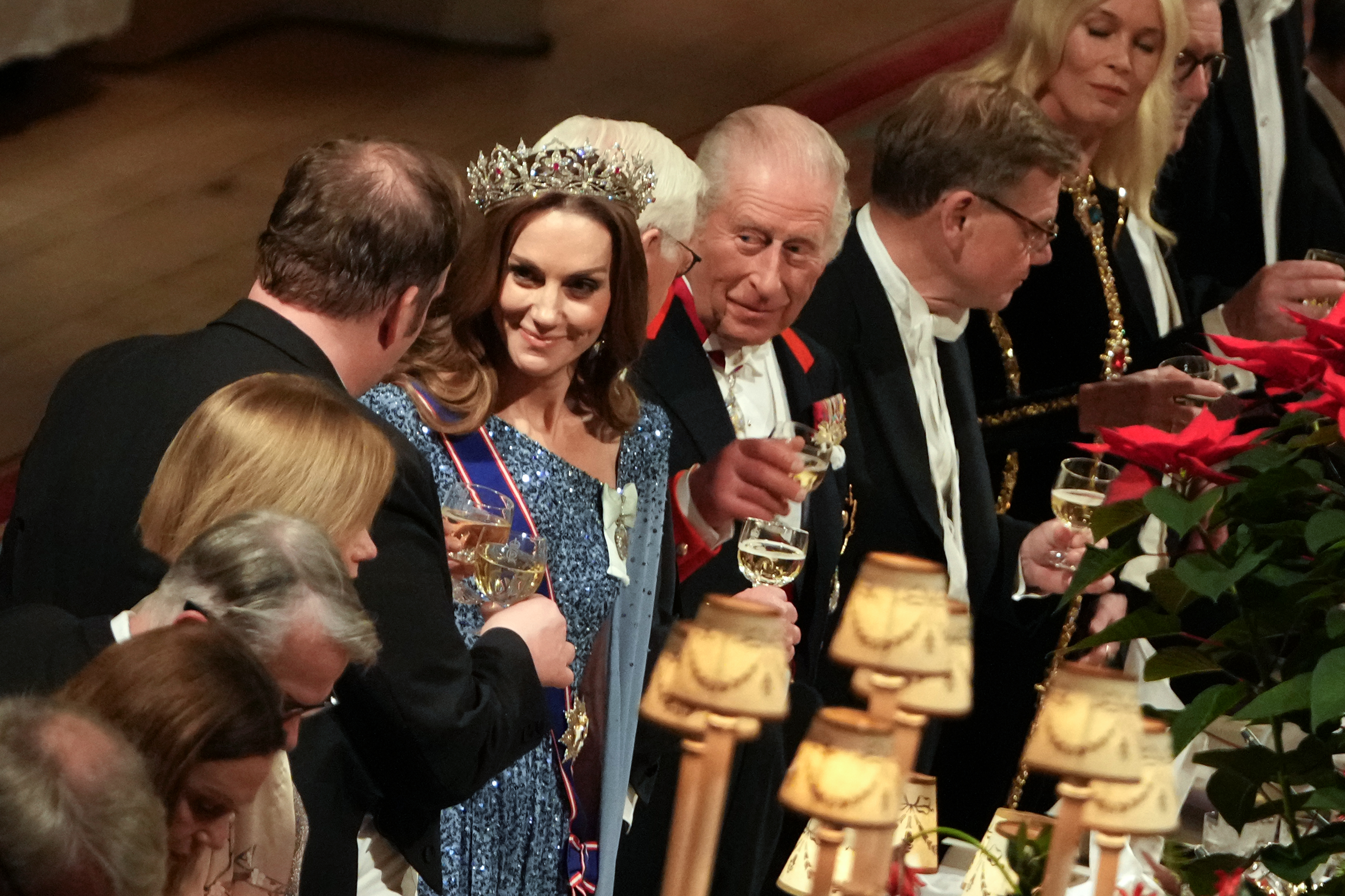Kate Middleton wearing a blue sequined gown and a tiara toasting at the German state banquet