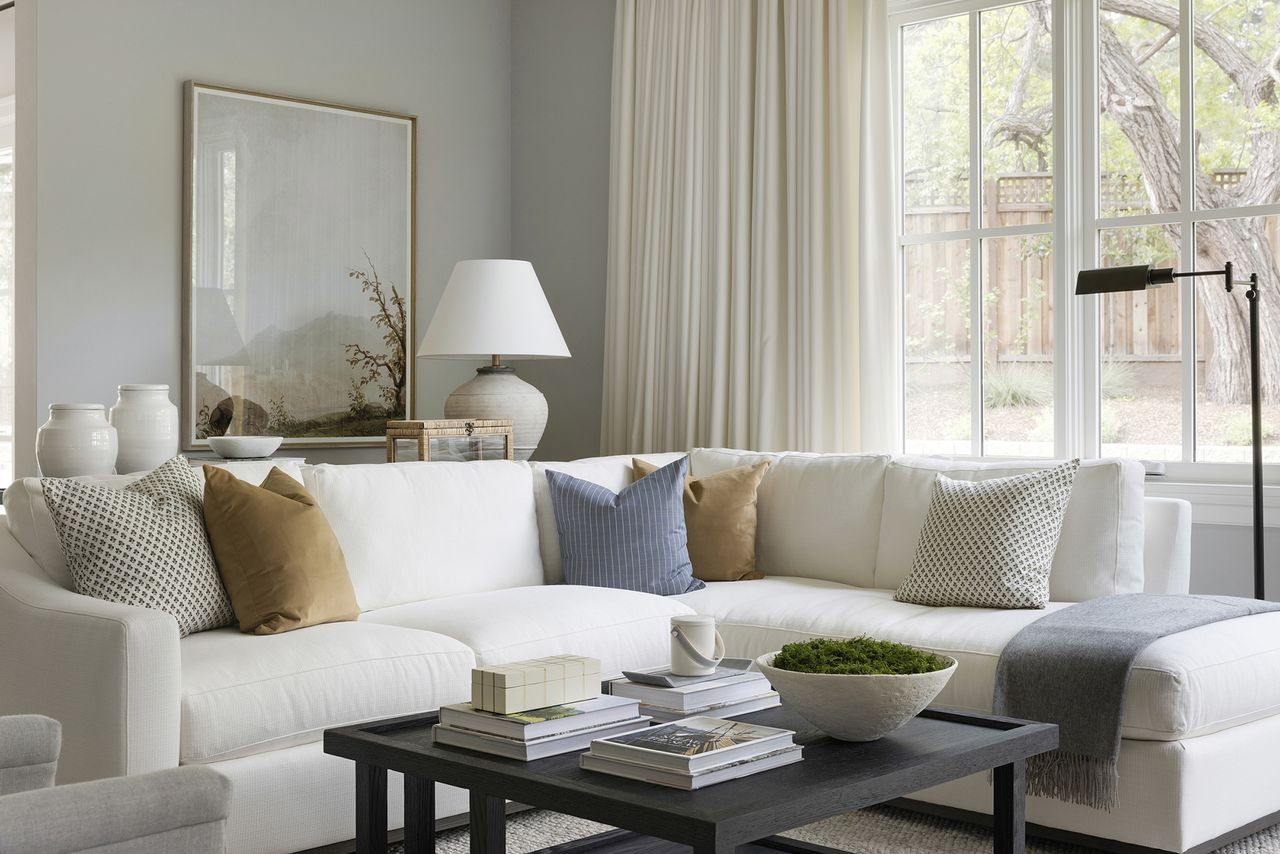 cream living room with white sofa with oversized art on the wall