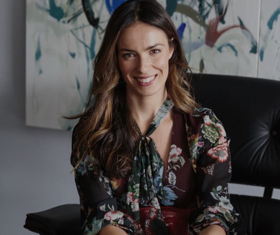woman smiling to camera wearing floral top