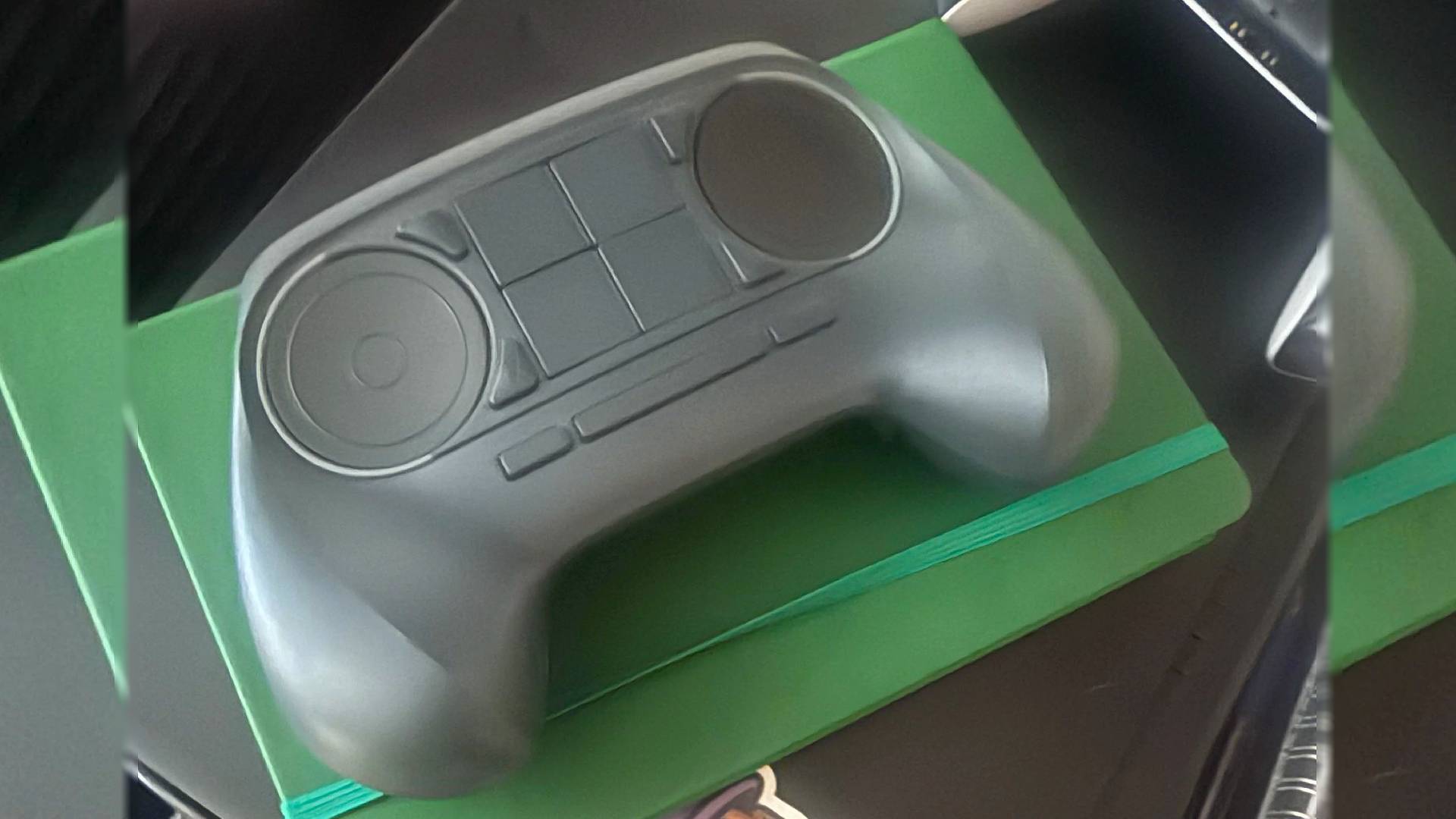 Steam Controller prototype sitting on green notebook.