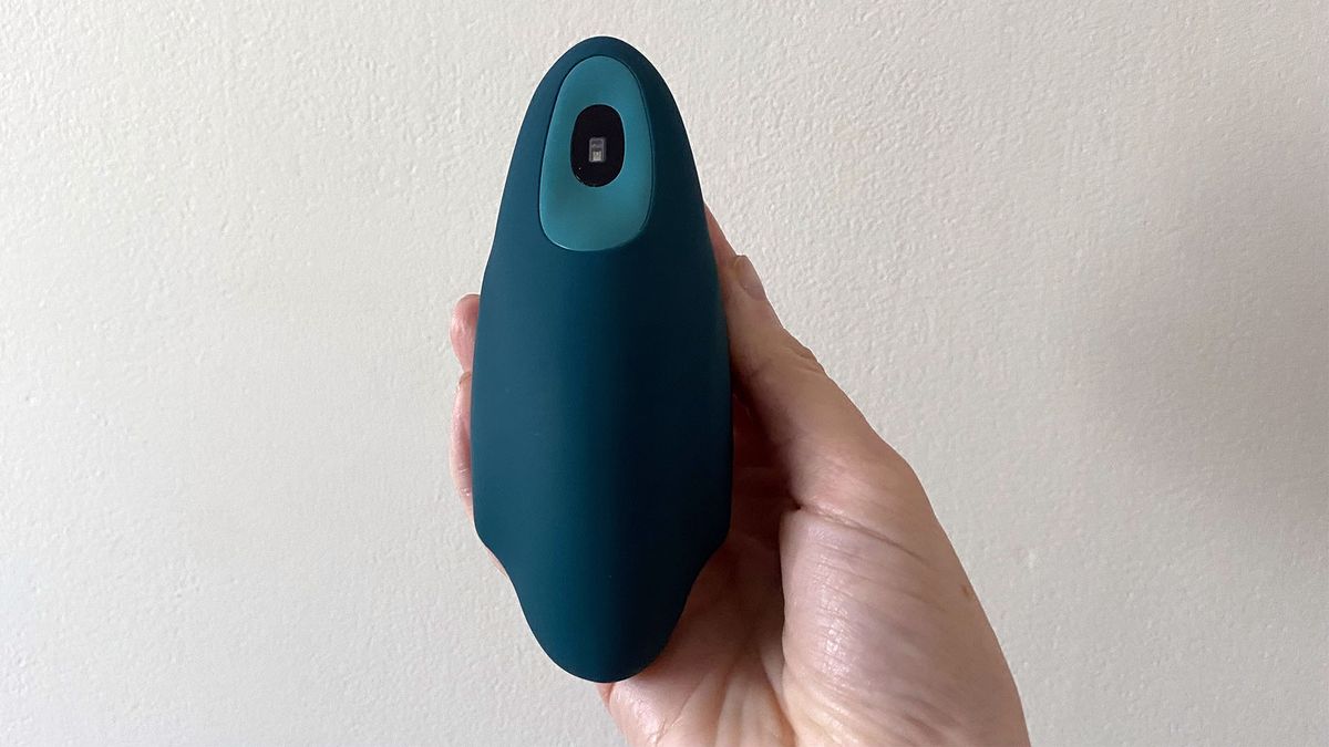 The moonbid breathing device held in our reviewer's hand. The 'wings' are in the inhale position, implying you should be breathing in