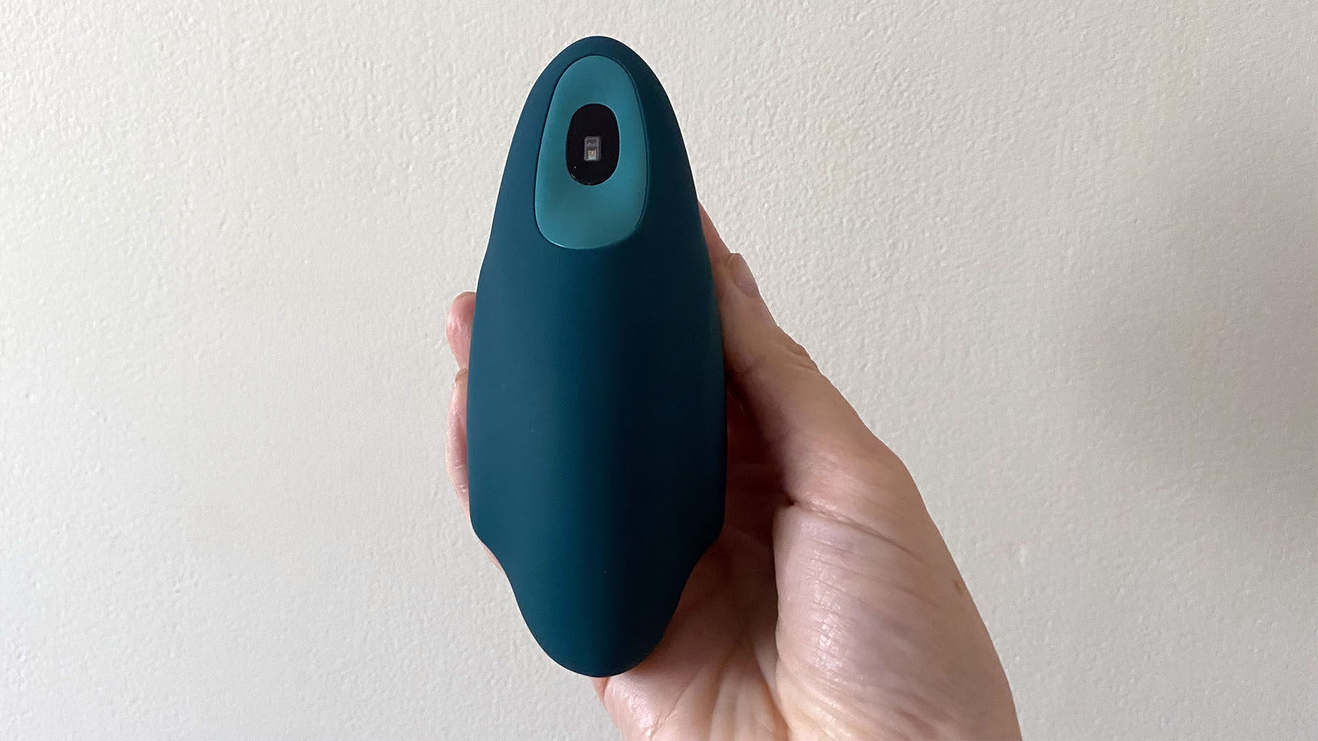 The moonbid breathing device held in our reviewer's hand. The 'wings' are in the inhale position, implying you should be breathing in