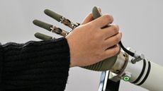 A human hand touches a robotic hand during the Global Developer Conference, organised by the Shanghai AI Industry Association, in February 2025