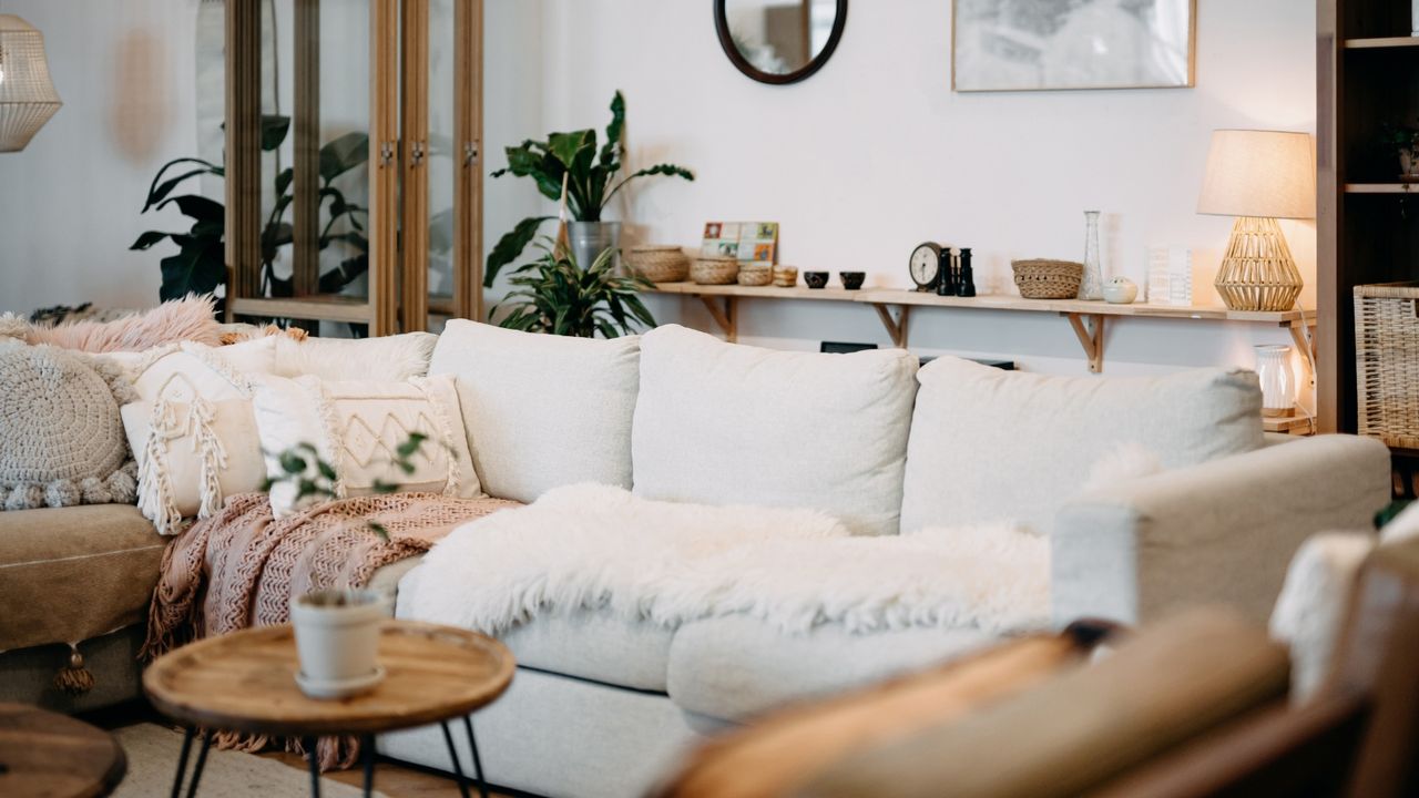 Living room interior with long cream couch, fluffy shag rug, and modern, stylish and cozy room design