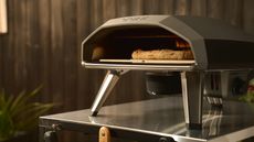 Ooni Koda 2 Rotating Stone on top of a stainless steel counter set in front of a black fence