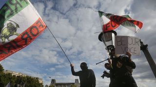 A protester in London's Trafalgar Square waves a flag aloft saying 'Freedom For Iran'.