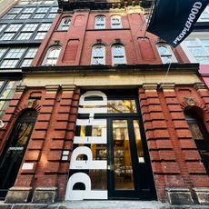 The brick exterior of Peoplehood's wellness studio in Manhattan, with a Peoplehood brand flag waving at the top of the door.