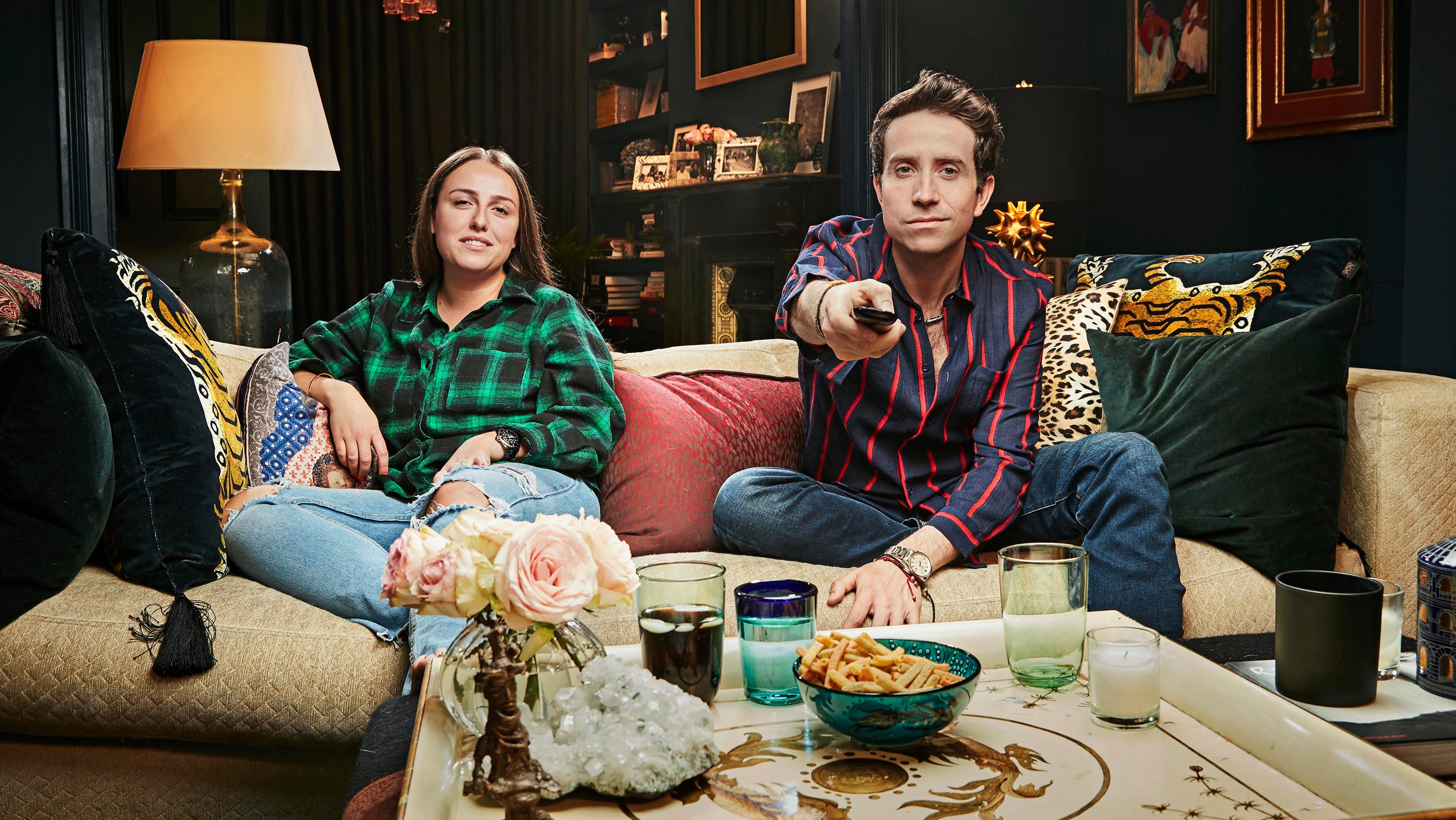 Nick Gromshaw on the sofa pointing a remote control at the camera with his niece, Liv, for Celebrity Gogglebox 2025