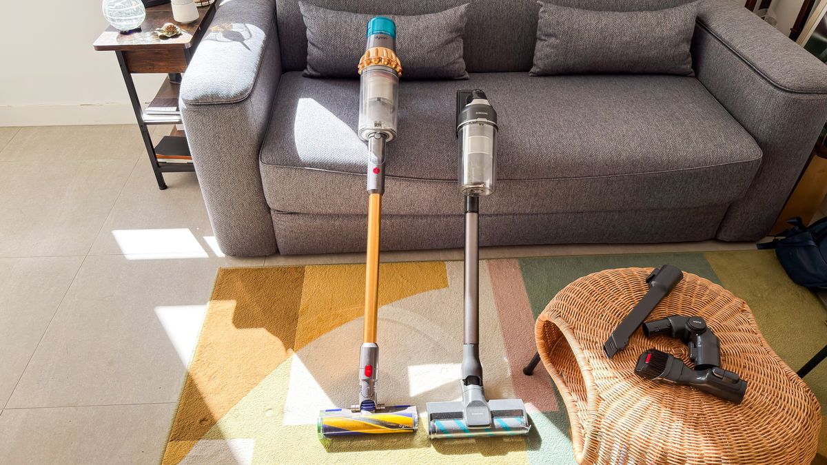 Samsung Jet 95S leaning against a sofa beside the Dyson V15 Detect Submarine