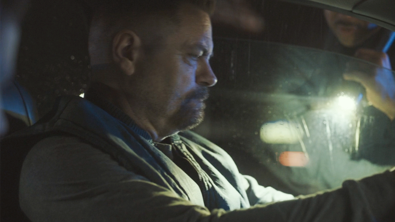 Nick Offerman in a car with a bright light behind him in Sovereign