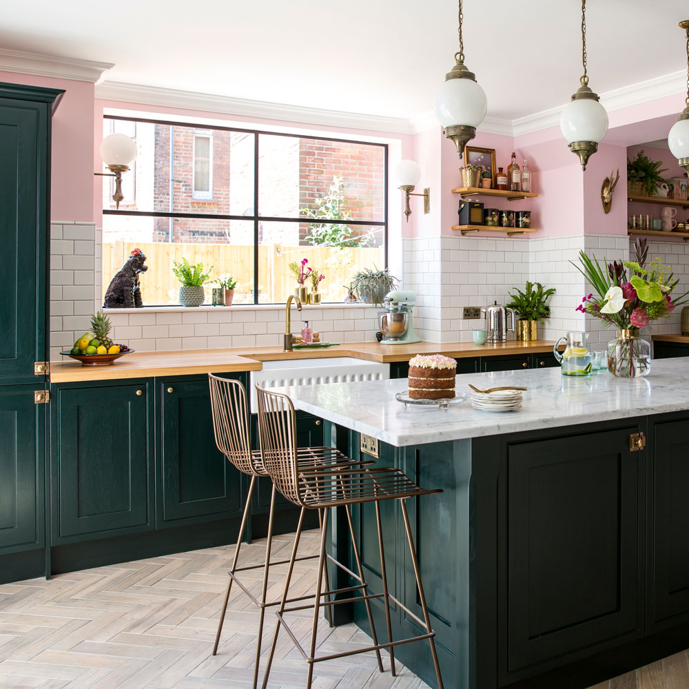 pink and white wall kitchen with black cupboards and marble counter-top, with wall-mounted shelves topped with accessories
