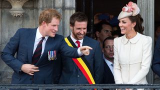 Prince Harry (L) makes a joke as Nicolas Martin, Acting Mayor of Mons and Catherine, Duchess of Cambridge (R) looks on from the balcony of the town hall as they attend a reception at the Grand Place on August 4, 2014 in Mons, Belgium