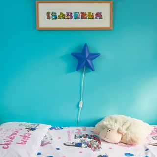 kids bedroom with blue wall and star lamp