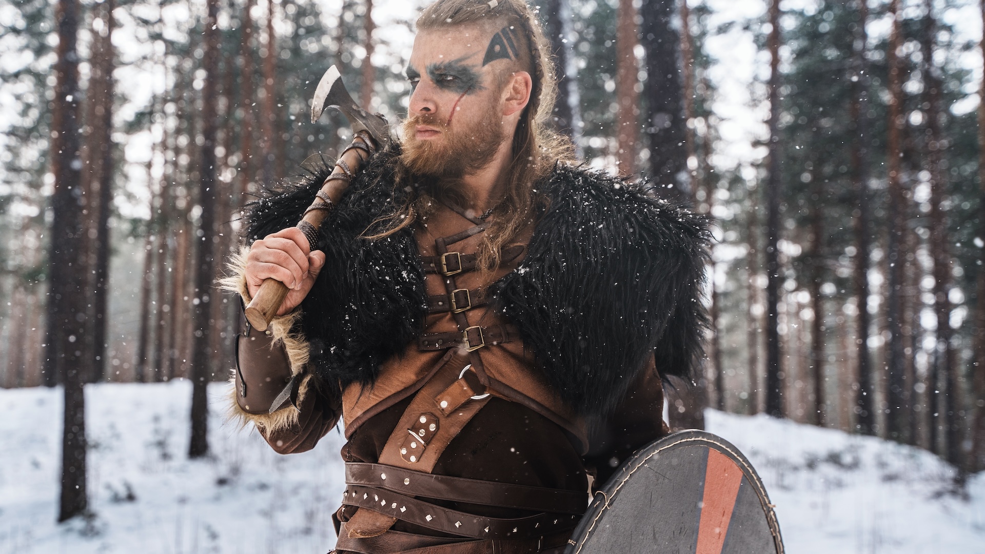 a man dressed up as a Viking warrior in a snowy forest