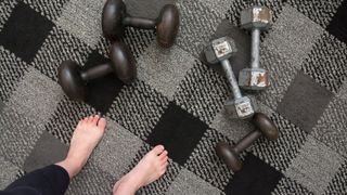 barefoot in the gym surrounded by weights