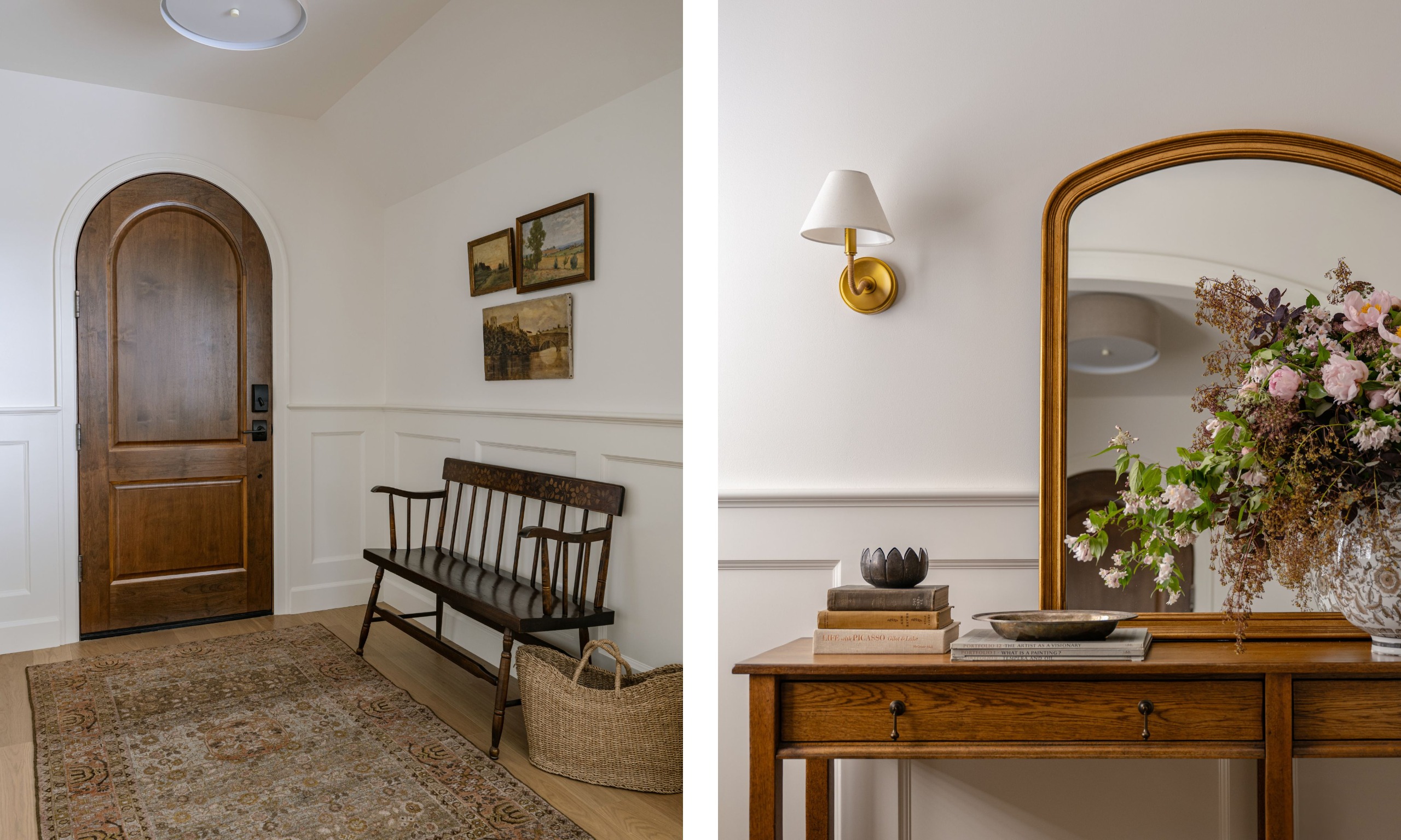 Two images of an entryway with white walls, wainscoting, wood flooring, a vintage rug, a dark wood arched front door, and a vintage bench, dresser, artwork, and a mirror with a brass wall sconce.