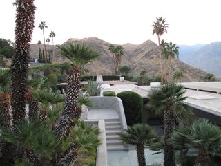 Roof top terrace view showing stairs below, palm trees and mountains