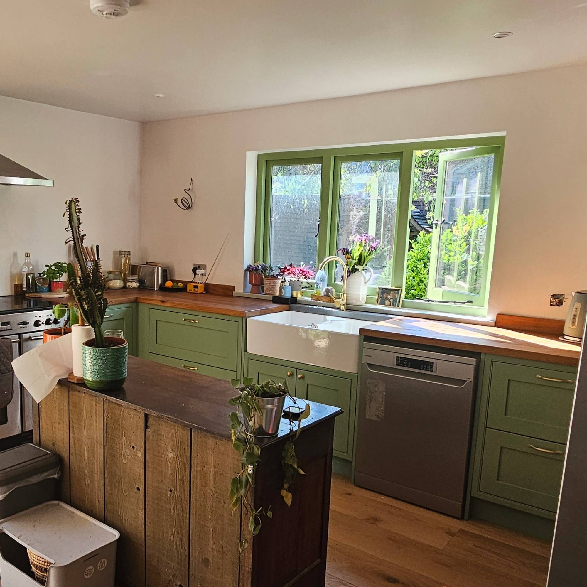 new green windows in green kitchen with wooden island