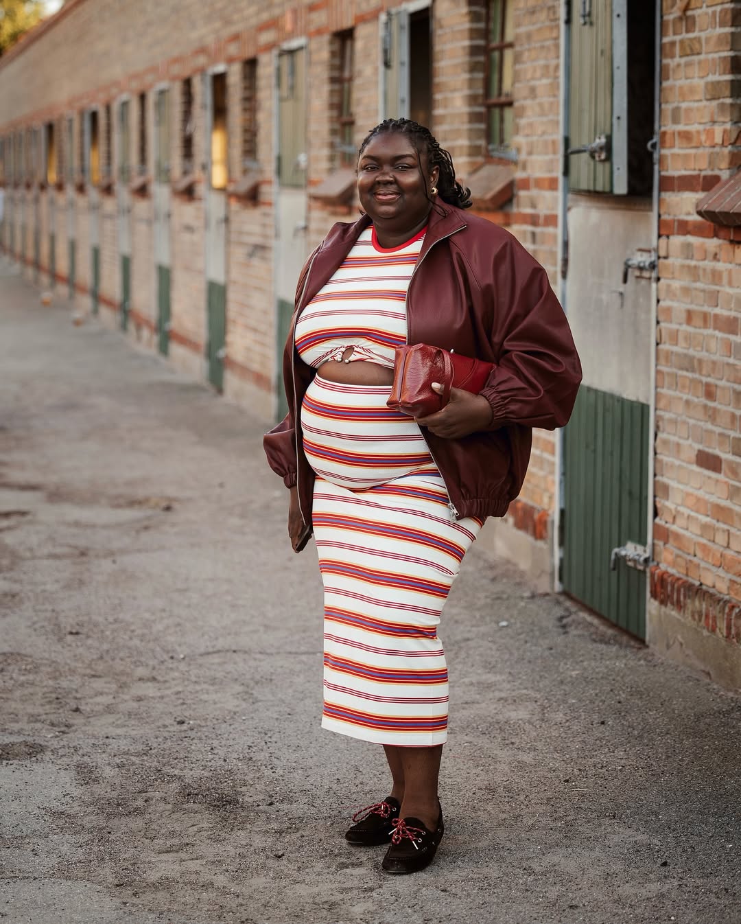 Influencer Abi Marvel wearing a printed co-ord, bomber jacket and boat shoes.