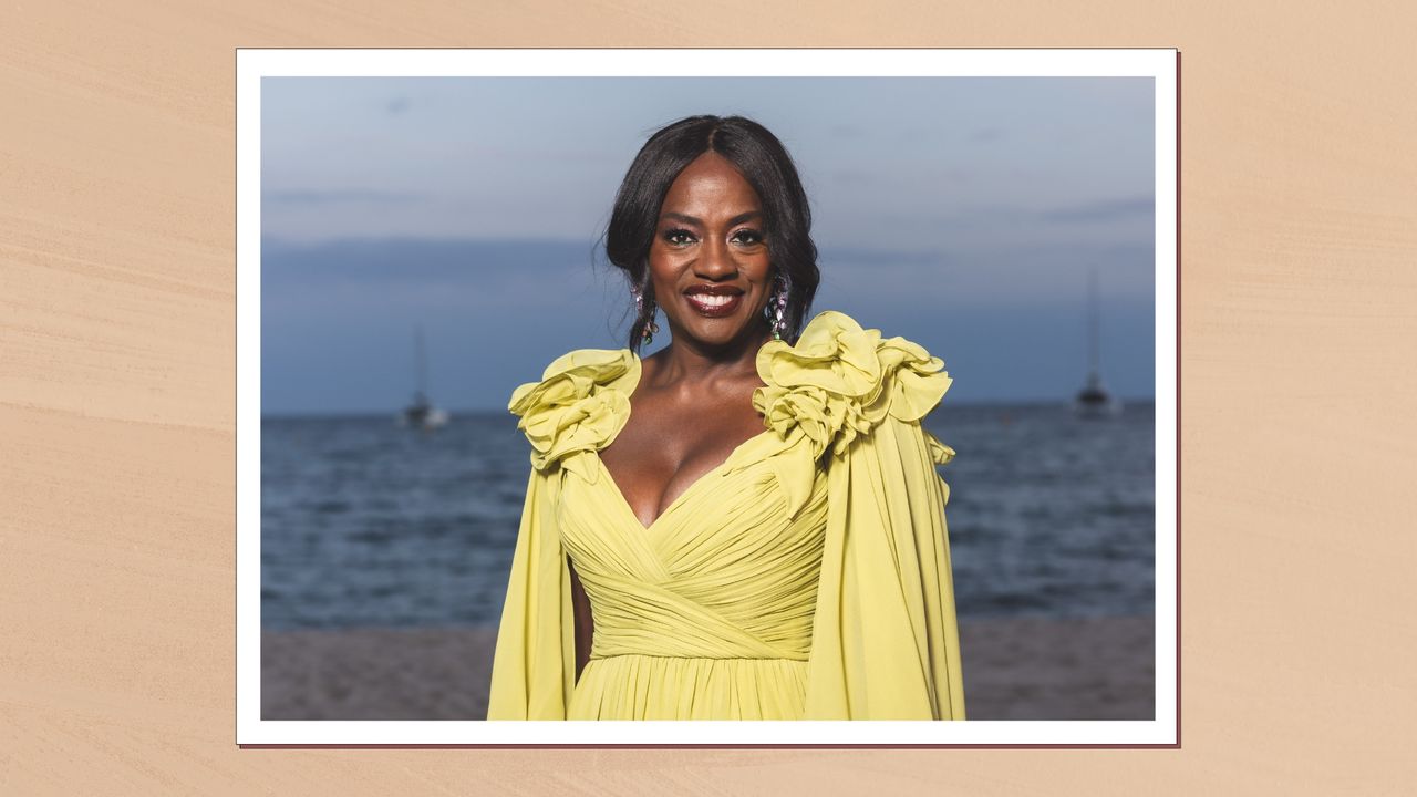 Viola Davis wears a yellow gown with shimmery eyeshadow, a peachy blush and glossy maroon lip.