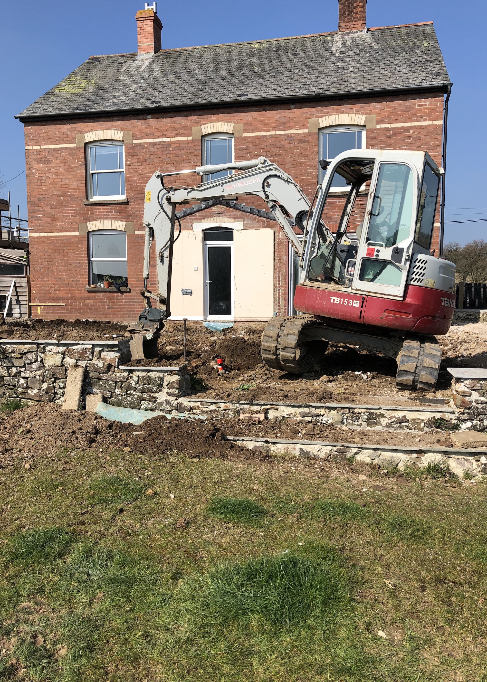 house with digger in front