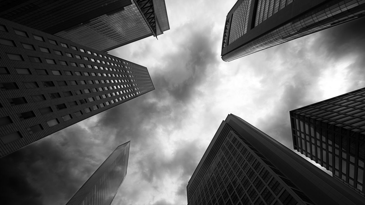 upward view of skyscrapers with dark clouds overhead