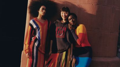 models wearing colorful striped sweater, striped dress, and striped skirt, shot in soft light